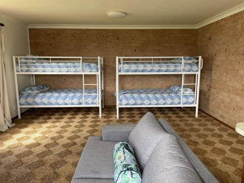 a living room with three bunk beds and a couch at Drift at Harrington in Harrington
