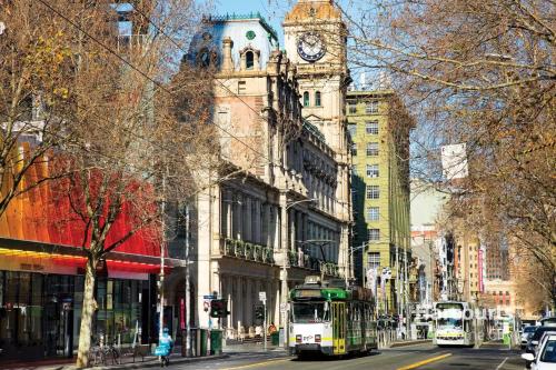 a busy city street with a clock tower on a building at Emporium-Melbourne Central-City view in shopping hotspots - Pokemon in Melbourne