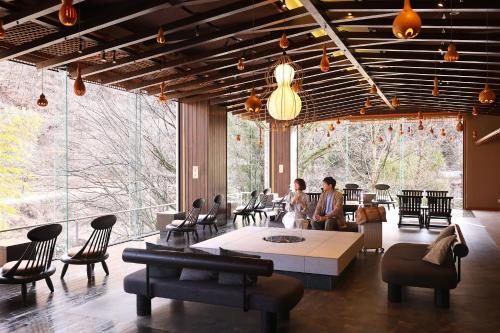 two people sitting in a room with large windows at TAOYA Kawaji in Nikko