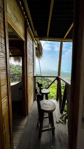 a room with a table and a stool on a porch at Puerto Alto Hostel in Santa Marta