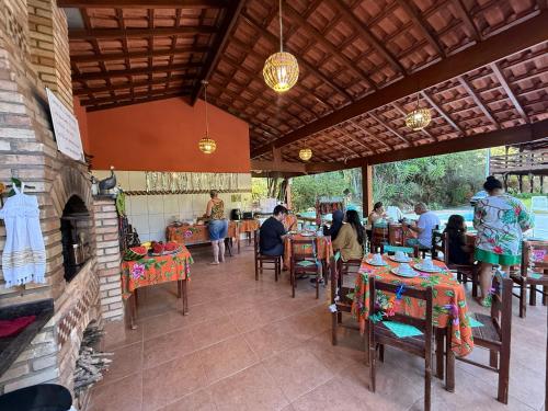 un gruppo di persone sedute ai tavoli di un ristorante di Casarão verde a São Luiz do Paraitinga