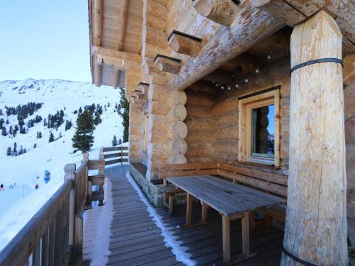 a porch of a log cabin with a wooden bench at Chalet in Wildkogel with Ski-In Ski-Out in Bramberg am Wildkogel