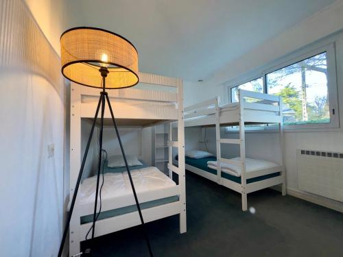 une chambre avec deux lits superposés et une lampe dans l'établissement Grande Maison Familiale Proche Plage, Piscines et Commerces – Idéal pour 8 Personnes - FR-1-323-546, à Saint-Jean-de-Monts