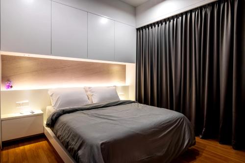 a bedroom with a large bed with a black curtain at Tropicana 218 Macalister Penang in George Town