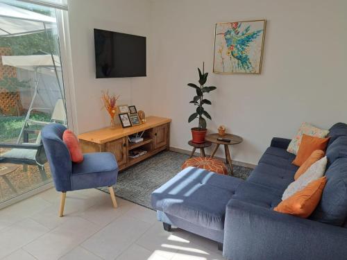 a living room with a blue couch and two chairs at Hogar Entre Viñas in Casablanca