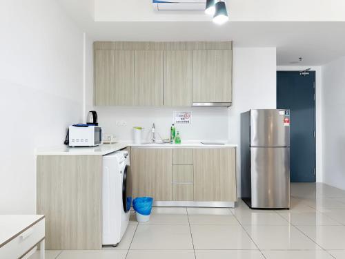 a kitchen with a refrigerator and a sink at Tropicana 218 Macalister Penang in George Town