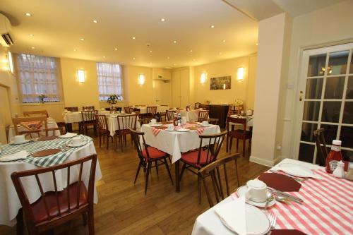 a dining room with tables and chairs in it at Ridgemount Hotel in London