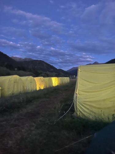a row of tents in a field at night at Karkyra Yurt Glamping in Sarytëbë