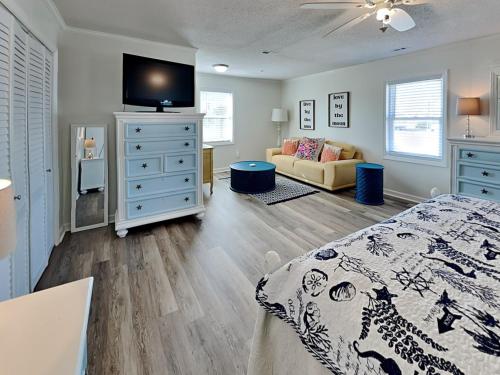 a bedroom with a bed and a dresser with a tv at Bellcove in Surf City