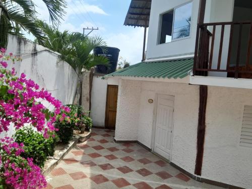 a courtyard of a house with pink flowers at CABAÑA PATIO ESPAÑOL in Santa Veronica