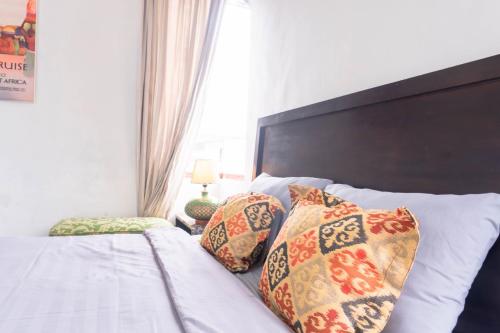 a bedroom with a bed with pillows on it at Aurora Holiday House Kintamani in Kintamani