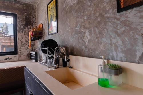 a kitchen counter with a sink and a window at Aurora Holiday House Kintamani in Kintamani