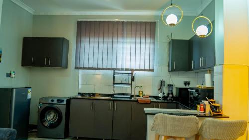 a kitchen with black cabinets and a stove top oven at Serene Homes 02 in Kampala