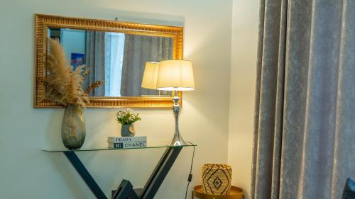 a lamp on a glass shelf in a room with a mirror at Serene Homes 02 in Kampala