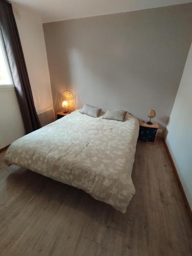 - une chambre avec un lit blanc et du parquet dans l'établissement Appartement des Georges du Tarn, à Compeyre