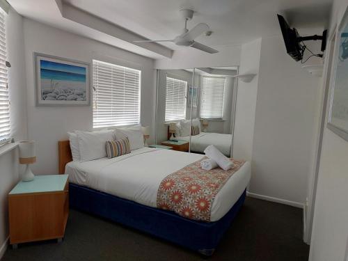a bedroom with a large bed with a ceiling fan at Stylish 1 Bedroom with Private Rooftop Spa at the Aegean in Mooloolaba