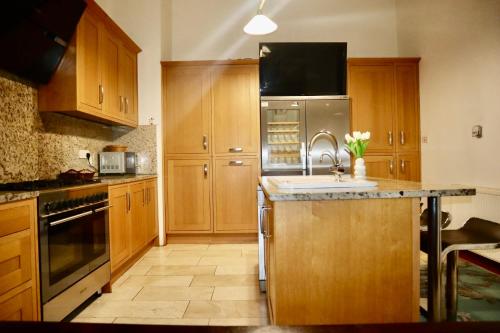 a kitchen with wooden cabinets and a sink at The Church V in Manchester
