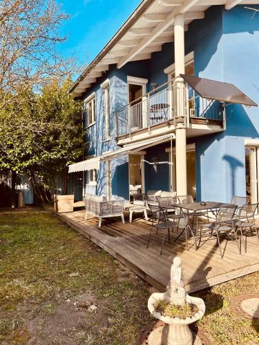 a blue house with a deck and a table and chairs at TheBlue Oak Apartments in Rust