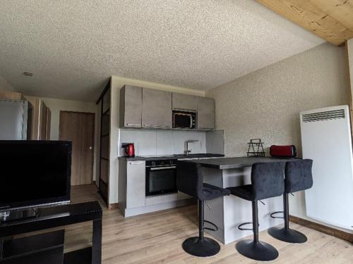 une cuisine avec un comptoir noir dans une pièce dans l'établissement Studio confortable à Châtel avec WiFi et parking couvert - FR-1-676-215, à Châtel