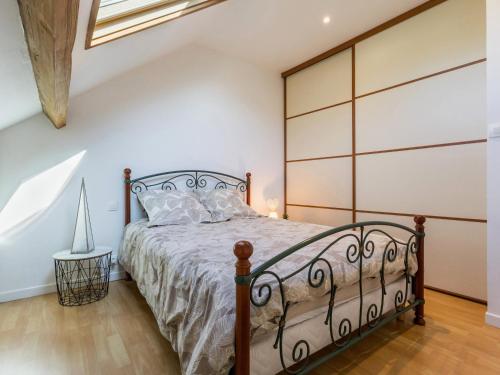 - une chambre avec un lit doté d'une tête de lit en métal dans l'établissement Charmant duplex rénové au cœur de Lajarrige avec wifi - FR-1-306-1297, à La Baule