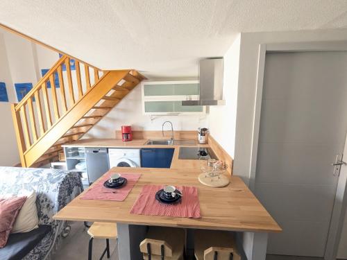 une petite cuisine avec une table en bois dans une pièce dans l'établissement Villa Cosy T2, 600m Plage, Climatisation, Parking - FR-1-797-62, à Port-la-Nouvelle