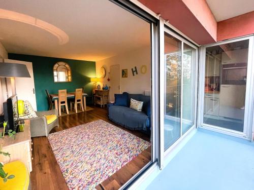 un salon avec un canapé et une porte coulissante en verre dans l'établissement Arcachon Centre - T2 Confortable avec Balcon et Parking Privé - FR-1-420-156, à Arcachon
