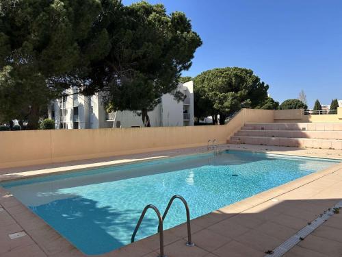 - une grande piscine avec des escaliers à côté d'un bâtiment dans l'établissement 2 Pièces avec Mezzanine, Résidence avec Piscine - FR-1-250-299, au Grau-du-Roi