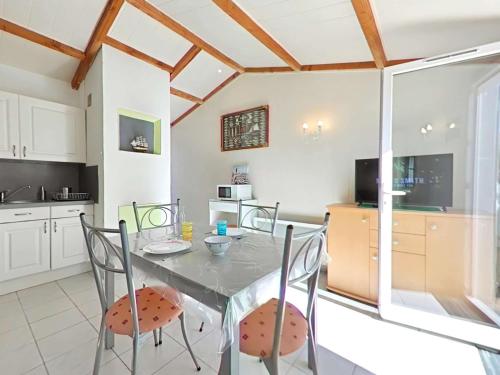 - une cuisine avec une table à manger et des chaises dans l'établissement Maisonnette vacances avec piscine à Bretignolles - FR-1-224A-74, à Bretignolles-sur-Mer