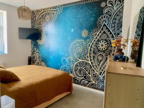 une chambre avec un lit et un mur bleu dans l'établissement F3 Moderne avec Climatisation et WiFi Proche des Thermes - FR-1-703-205, à Amélie-les-Bains-Palalda