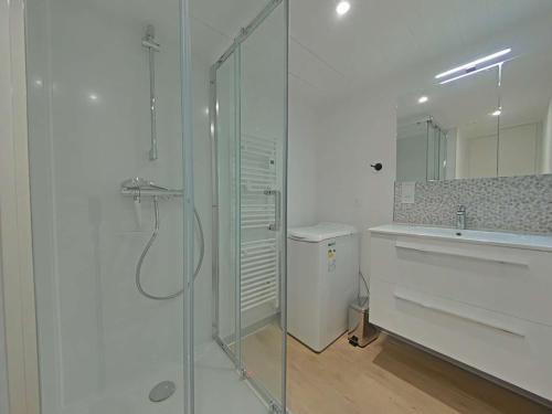 une salle de bain blanche avec une douche et un lavabo dans l'établissement Maison 2 pièces, 4 pers, Piscine, Parking, Bretignolles-sur-Mer - FR-1-224A-75, à Bretignolles-sur-Mer