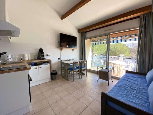 Il comprend une cuisine et un salon avec un lit et une table. dans l'établissement Appartement 2 pièces en duplex avec terrasse et piscine à Balaruc-les-Bains - FR-1-553-301, à Balaruc-les-Bains