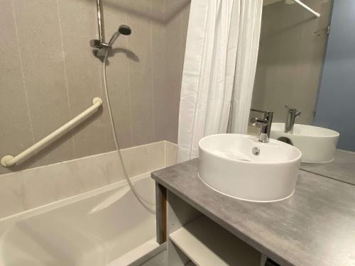 une salle de bain blanche avec un lavabo et une douche dans l'établissement Appartement 2 pièces en duplex avec terrasse et piscine à Balaruc-les-Bains - FR-1-553-301, à Balaruc-les-Bains