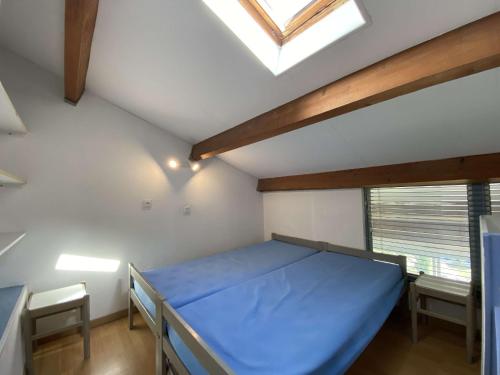 - une chambre avec un lit bleu et une lucarne dans l'établissement Appartement 2 pièces en duplex avec terrasse et piscine à Balaruc-les-Bains - FR-1-553-301, à Balaruc-les-Bains