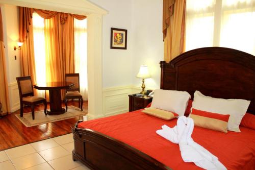 a bedroom with a large bed with a red blanket at Sportsmens Lodge - Gentlemen's Club in San José
