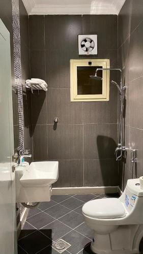 a bathroom with a white toilet and a sink at ليلك سويت للشقق المخدومة in Taif