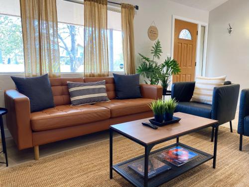 a living room with a brown couch and a table at Pax Sacellum Kanab Home for Southern Utah Hiking in Kanab