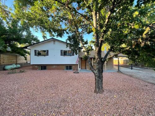 a house with a tree in front of it at Pax Sacellum Kanab Home for Southern Utah Hiking in Kanab