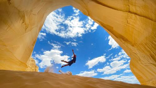 a person jumping in the air in a desert at Pax Sacellum Kanab Home for Southern Utah Hiking in Kanab