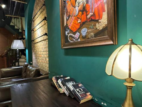 a table with a lamp and a painting on a wall at Sapa Centre Hotel in Sa Pa