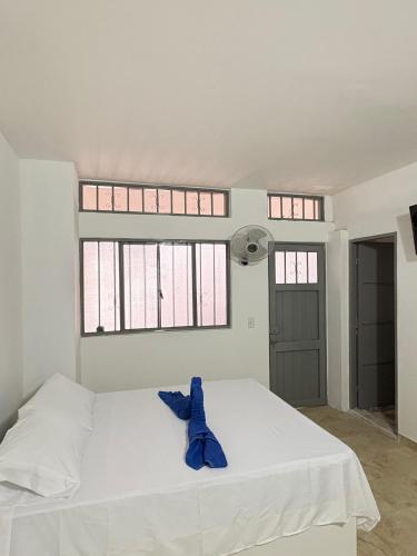 a white bed in a room with two windows at Hotel Dauphin Rest in La Dorada