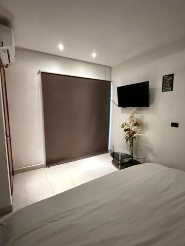 a bedroom with a large sliding door with a television at Suites vergel planta baja in Orizaba