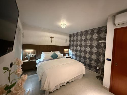a bedroom with a bed and a cross on the wall at Suites vergel planta baja in Orizaba