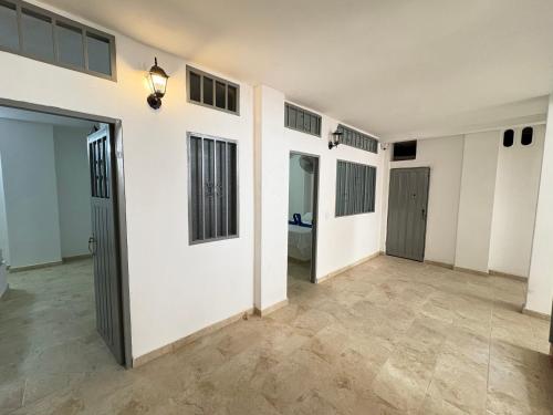 an empty room with white walls and tile floors at Hotel Dauphin Rest in La Dorada