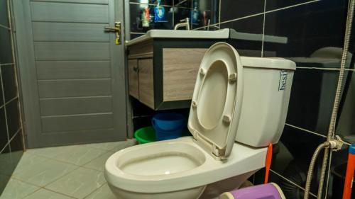 a bathroom with a toilet with the seat up at Serene Homes 02 in Kampala