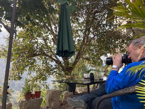 a man taking a picture of a table and an umbrella at Miknaon Farmstay in Pedong