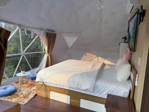 a bedroom with a bed and a large window at Plum Homestay in Dồng Văn