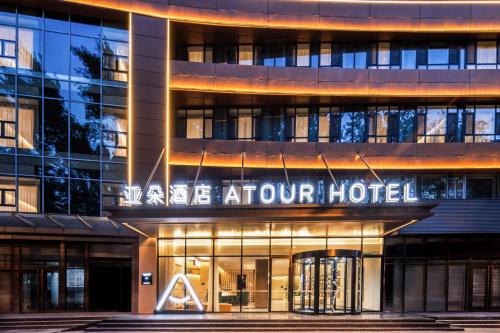a building with a sign for a hotel at Atour Hotel Tianjin Wudadao Tonglou Subway Station in Tianjin