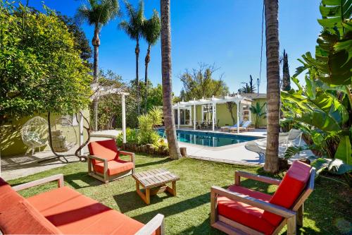a backyard with chairs and a pool and a house at Villa La Verde - Newly Designed 4BR Villa with Pool & Guesthouse by Topanga in Los Angeles
