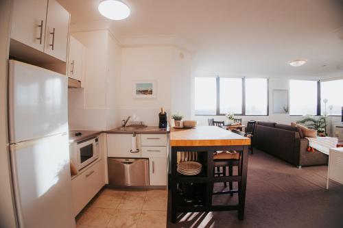 a kitchen with a refrigerator and a table in it at RiverView One-Bedroom Apartment Brisbane CBD in Brisbane
