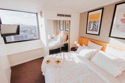 ein Hotelzimmer mit einem Bett und einem Fenster in der Unterkunft RiverView CBD Apartment Level 22 in Brisbane